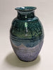Raku-fired ceramic vase with green glossy glaze over blue matt glaze